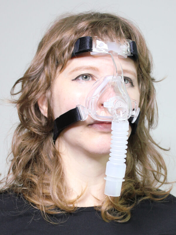 Photograph of Sunset Deluxe Nasal CPAP mask in use (on female model)