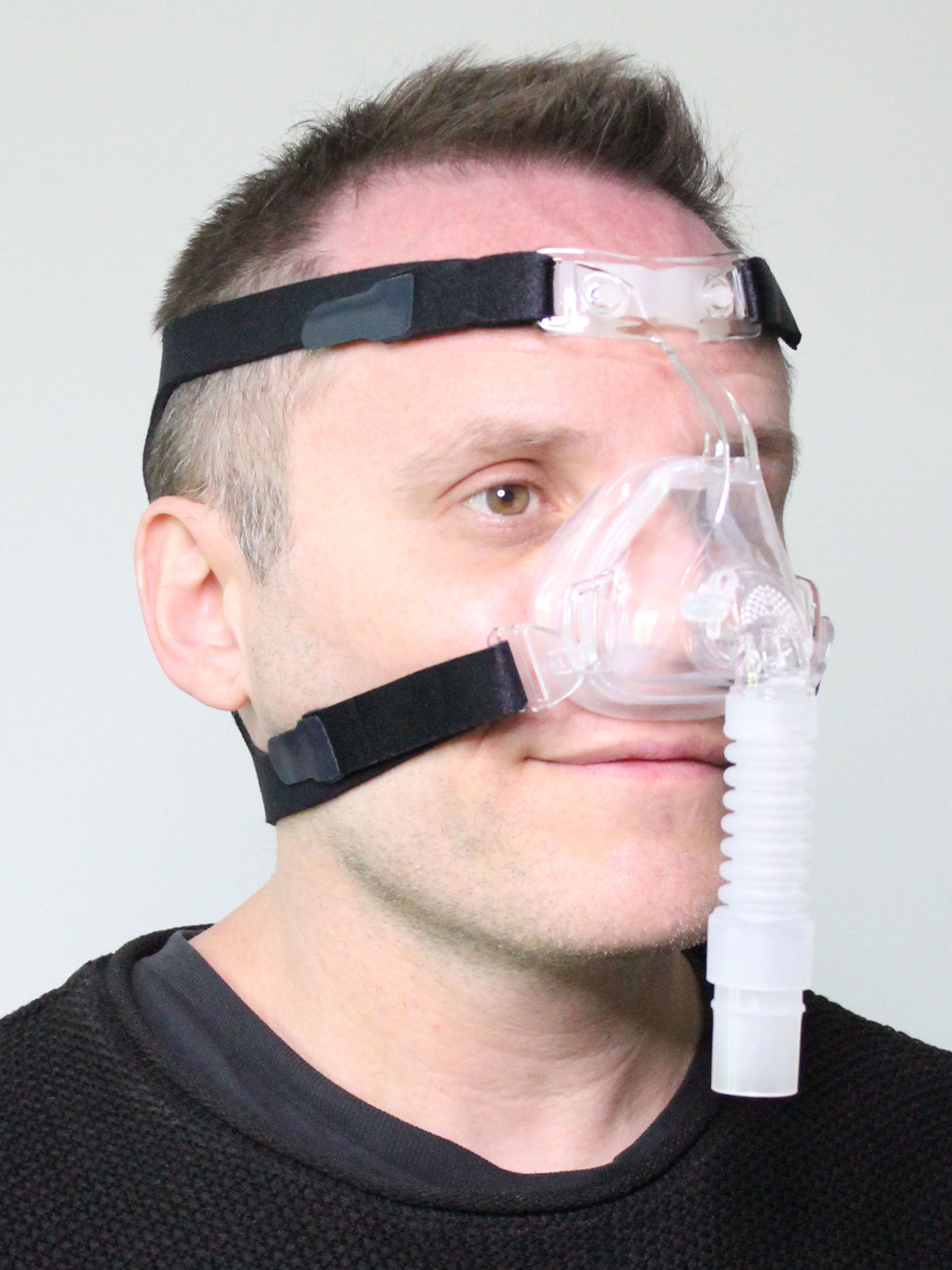 Photograph of Sunset Deluxe Nasal CPAP mask in use (on male model)
