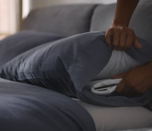 photograph of person placing nora pillow insert under pillow