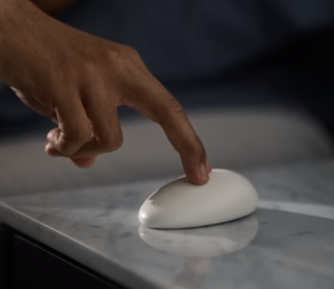 photograph of person's hand activating the Smart Nora pebble