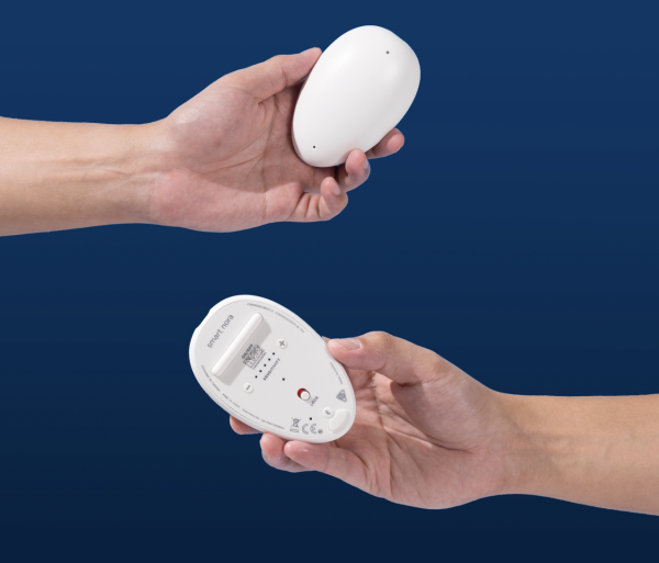 Photograph of hands holding Smart Nora pebble device