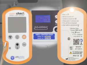 Photo of Smart Check casting flashlight beam onto an oxygen concentrator in a darkened room