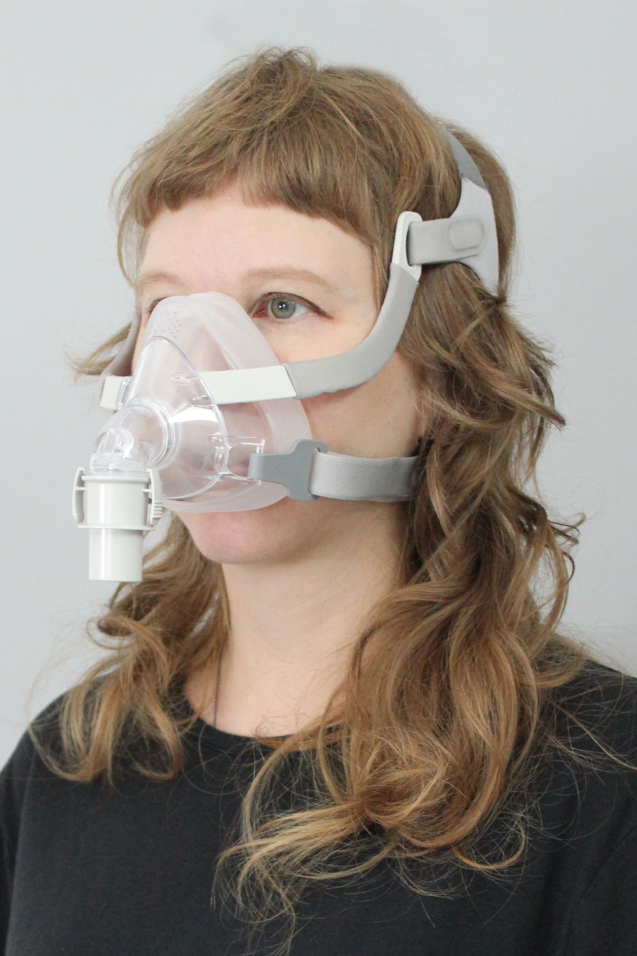 A woman wearing the Sunset Vesper Full Face CPAP Mask