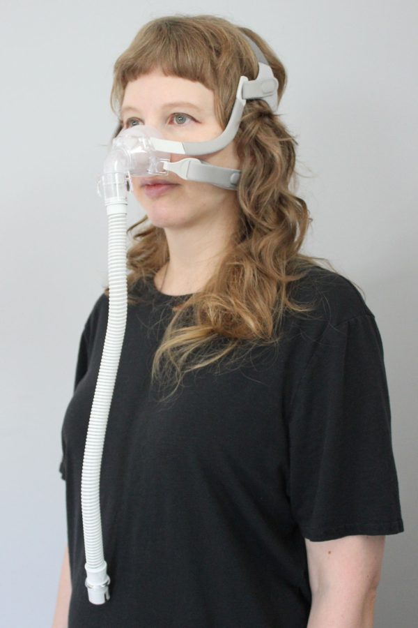 A woman wearing the Sunset Vesper Nasal CPAP Mask