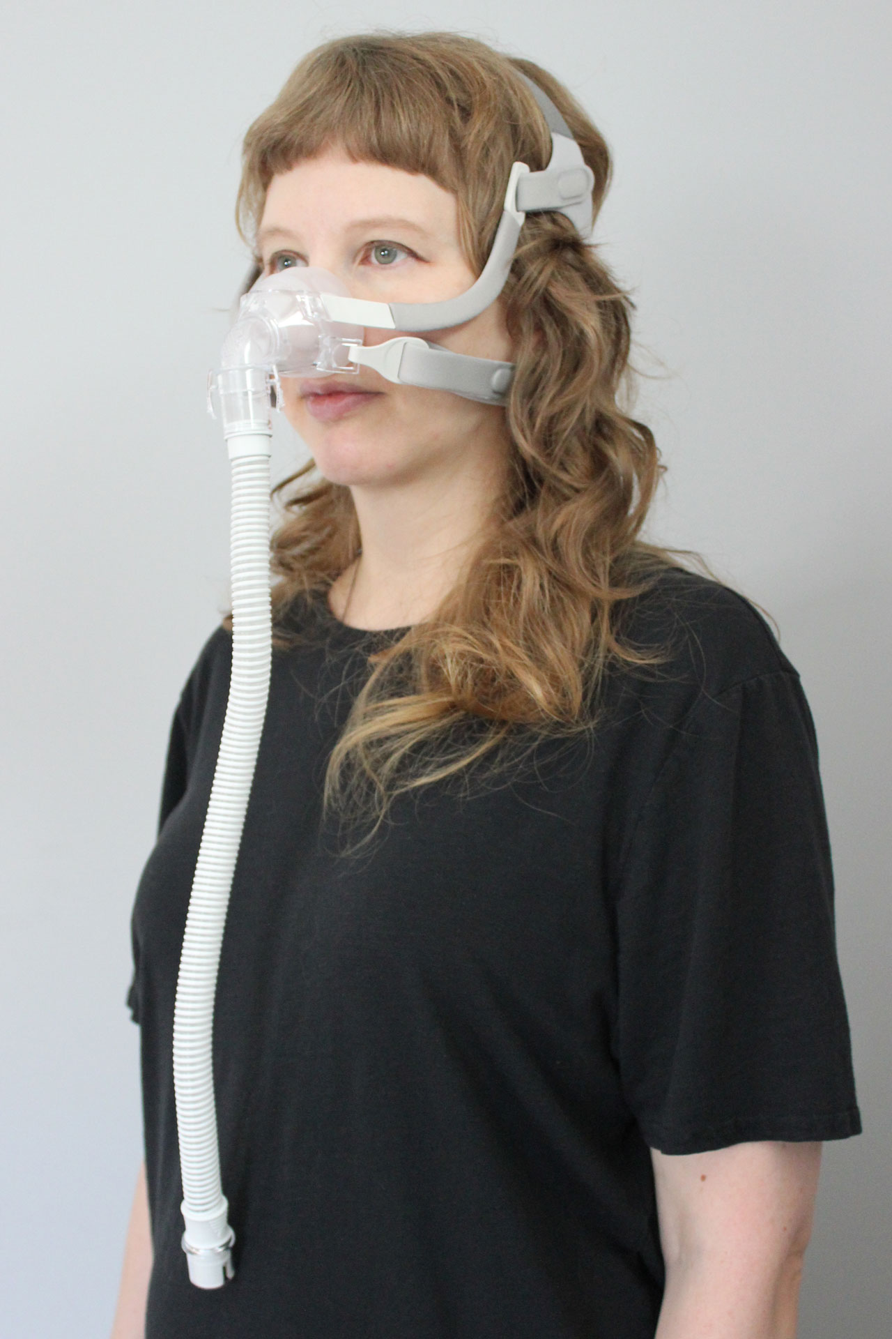 A woman wearing the Sunset Vesper Nasal CPAP Mask